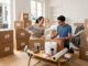 Du T1 au T5 - kit de déménagement : image ou photo d'un salon lumineux en plein déménagement avec plusieurs cartons soigneusement empilés. Chaque carton porte un petite étiquette. Au centre, un kit de déménagement complet avec du ruban adhésif, du papier bulle, un marqueur et des protections.