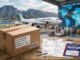 Expédier à l'international : image ou photo d'une scène professionnelle montrant un colis prêt à partir depuis La Réunion vers l’international. Le colis est posé sur une table, accompagné d’une facture commerciale, d’un formulaire douanier et d’un passeport de transport.